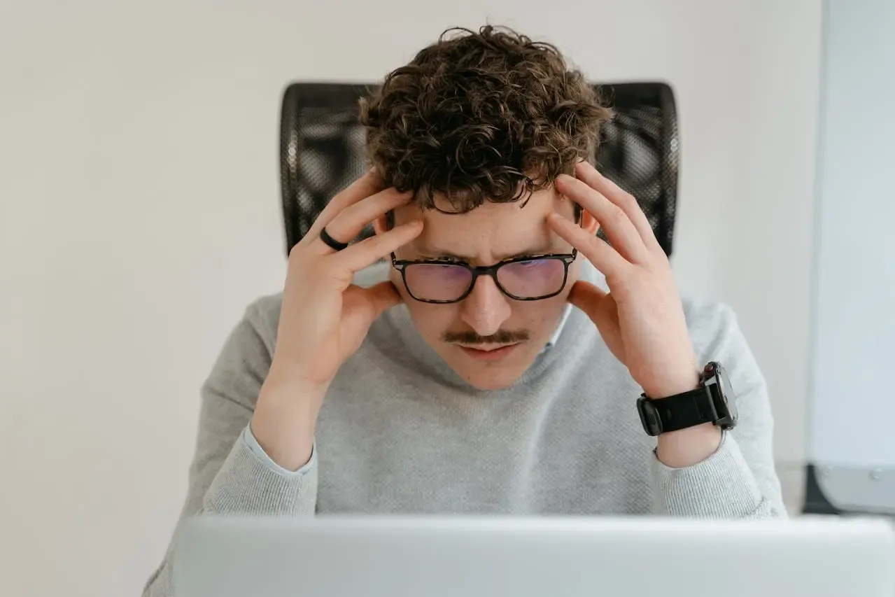 Homme concentré portant des lunettes anti-lumière bleue devant un ordinateur, illustrant la protection visuelle contre la fatigue numérique avec Regards Uniques.