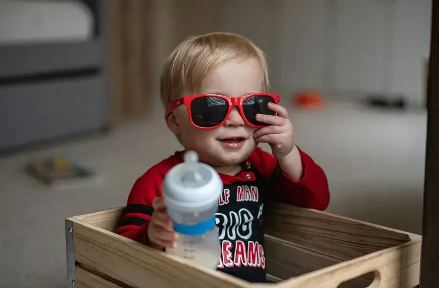 enfant avec des lunettes de soleil rouge